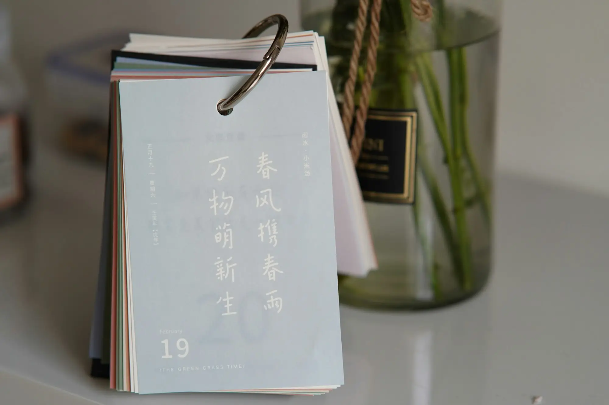 Flip calendar on a desk beside a small vase